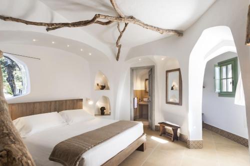 a bedroom with a bed in a white room at Gallicantu Stazzo Retreat in Luogosanto