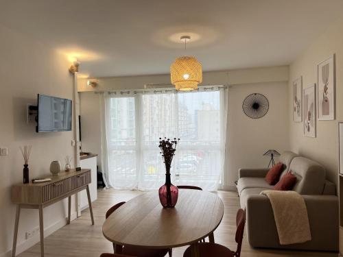 un salon avec une table et un canapé dans l'établissement L'Evasion, à Calais