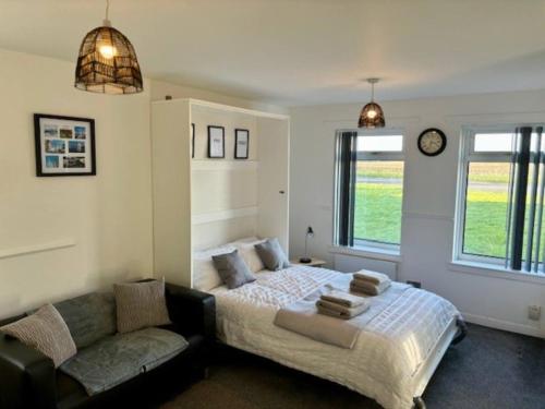 a bedroom with a bed and a couch at Modern apartment in Stenhousemuir in Stenhousemuir