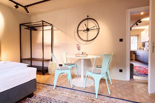 a bedroom with a table and chairs and a clock at XZLLENZ Küche Bad S-Bahn Parken Smart-TV Wellbeing in Neunkirchen am Sand