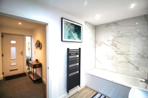 a bathroom with a walk in shower next to a sink at 2 Bed Bungalow - Parking - New Build - High End Furnishings - Wheel Chair Accessible - Large Enclosed Garden - Dog Friendly in Rotherham