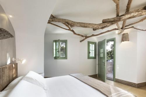 a bedroom with a bed and a tree branch on the ceiling at Gallicantu Stazzo Retreat in Luogosanto