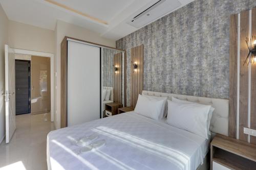 a bedroom with a white bed and a wall at Seasight Suites in Kusadası