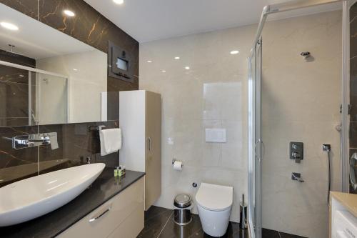 a bathroom with a sink and a toilet and a shower at Seasight Suites in Kusadası