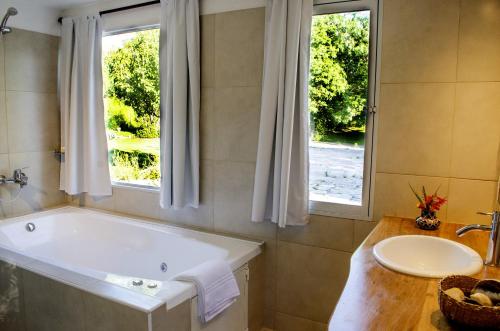 baño con bañera, lavabo y ventana en Quebrada Mansa en Nono