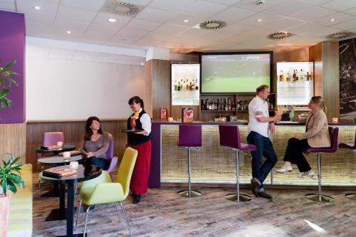 a group of people standing around a bar at Mercure Hotel Hamburg am Volkspark in Hamburg
