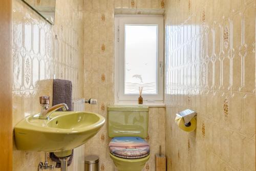 a bathroom with a sink and a toilet and a window at Seeperle Lochau - Der See ruft! in Lochau