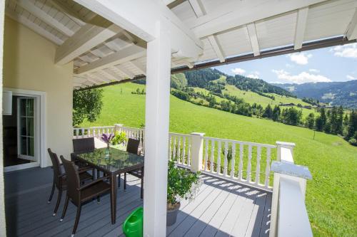 a porch with a table and chairs and a view at Appartements Lehenhof in Sankt Johann im Pongau