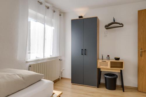a bedroom with a large gray cabinet and a desk at Seeperle Lochau - Der See ruft! in Lochau
