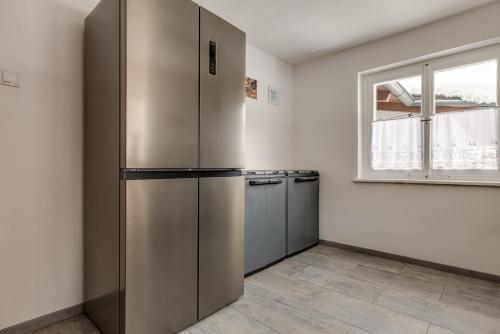 a kitchen with a large stainless steel refrigerator at Seeperle Lochau - Der See ruft! in Lochau