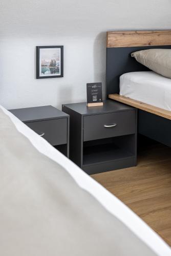 a bedroom with a bed and two night stands at Seeperle Lochau - Der See ruft! in Lochau