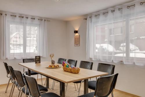 a dining room with a wooden table and chairs at Seeperle Lochau - Der See ruft! in Lochau