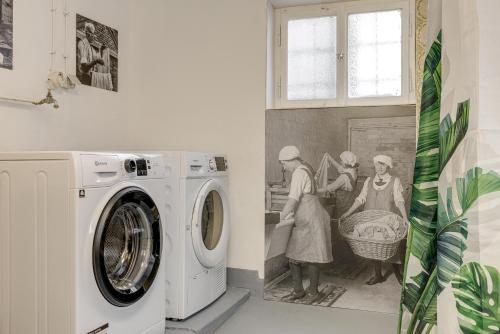 a laundry room with a washing machine and a painting at Seeperle Lochau - Der See ruft! in Lochau