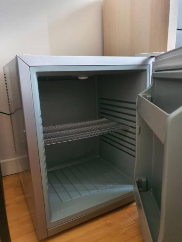 an empty refrigerator with its door open in a kitchen at Room - Garden - private bathroom in Turin