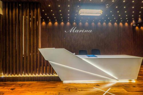 a white desk in a room with some chairs at Super Townhouse Marina in Rānchī