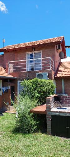 a brick house with a bench in the yard at Ayres Serranos in Merlo