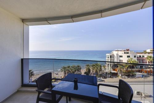 a balcony with a table and chairs and a view of the ocean at Seasight Suites in Kusadası