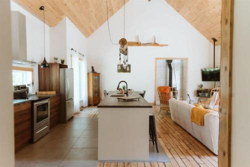 a kitchen with white walls and wooden ceilings at L'Echappee Belle - lake and SPA in Saint Come