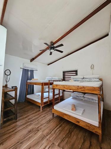 a room with two bunk beds and a ceiling fan at Big BamBoo Beach Resort Sipalay in Sipalay