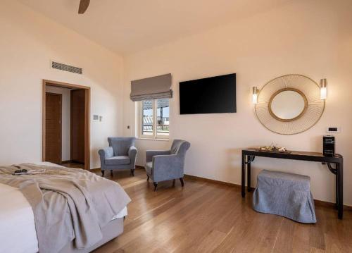 a bedroom with a bed and a desk and a mirror at Cretan Dream Resort & Spa in Stalos