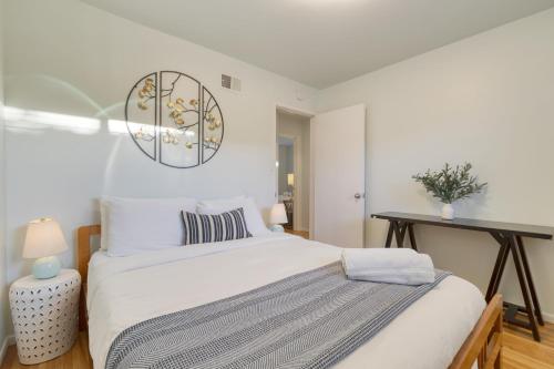 a white bedroom with a bed and a clock on the wall at Goleta Getaway by AvantStay Private Backyard 1.5mi to the Beach in Santa Barbara