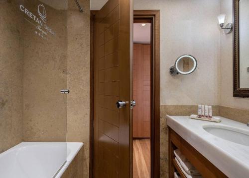 a bathroom with a shower and a tub and a sink at Cretan Dream Resort & Spa in Stalos