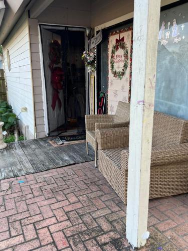 a porch with two wicker chairs on a house at Blue Beauty located by LSU in Baton Rouge