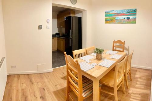a dining room with a table with chairs and a refrigerator at Long Eaton house sleeps 6 & double sofabed in Long Eaton