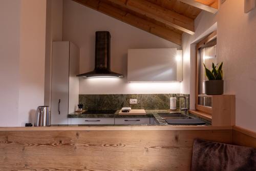 a kitchen with white cabinets and a stove top oven at GreenWood Chalet - Spacious Alpine Retreat with Mountain Views in Vodo Cadore