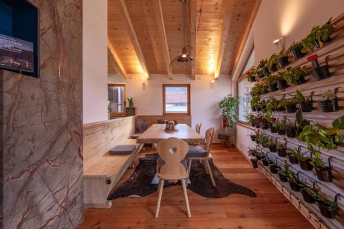 a dining room with a table and chairs and plants at GreenWood Chalet - Spacious Alpine Retreat with Mountain Views in Vodo Cadore