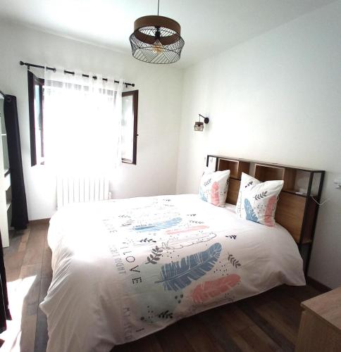 une chambre avec un lit avec des draps blancs et une fenêtre dans l'établissement appartement 5 personnes à la montagne, à La Plagne Tarentaise