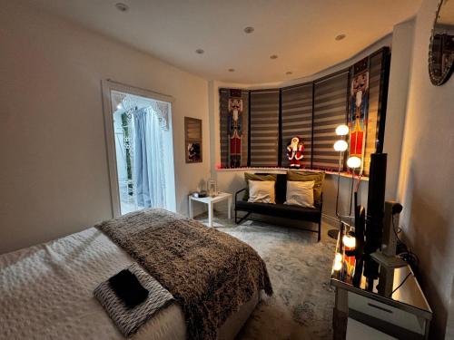 a bedroom with a bed and a couch at Modern One Bedroom Flat in Twickenham for Business Travelers in Hanworth