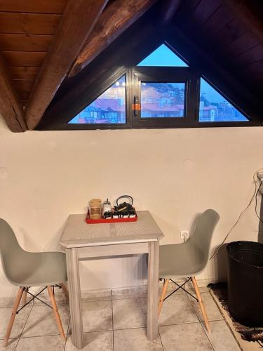 a table and two chairs in a room with windows at Pandoras House Arachova in Arachova