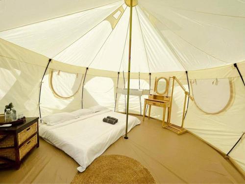 a bedroom with a tent with a bed and a chair at Damboung Bungalow in Kampot