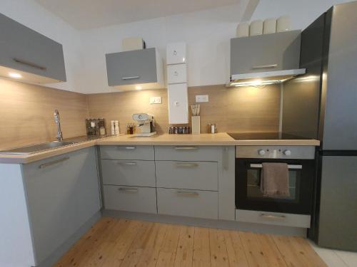 a kitchen with white cabinets and a sink and an oven at Hyper centre à 2 pas du port in Audierne