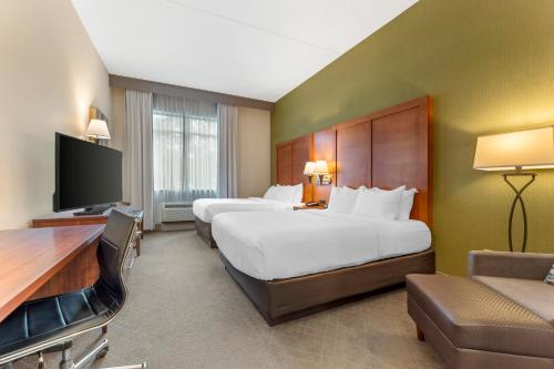 a hotel room with two beds and a desk at Comfort Inn & Suites LaVale - Cumberland in La Vale