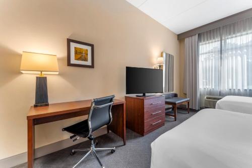 a hotel room with a desk and a bed and a television at Comfort Inn & Suites LaVale - Cumberland in La Vale