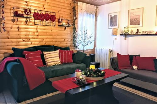 a living room with a green couch and red pillows at Kuća za odmor-Kućica in Mrkopalj