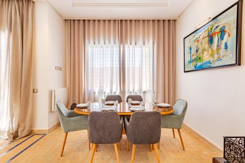 Un comedor con mesa y sillas en Villa Riad Targa 10 min de GUELIZ Piscine privee, en Marrakech