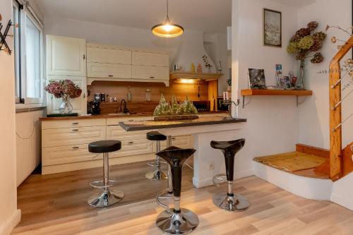 - une cuisine avec un comptoir et des tabourets dans l'établissement La Villa, à Viviers-du-Lac