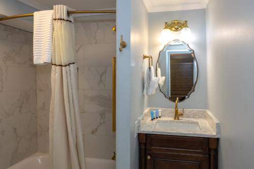 a bathroom with a sink and a shower and a mirror at Eliza Thompson House, Historic Inns of Savannah Collection in Savannah