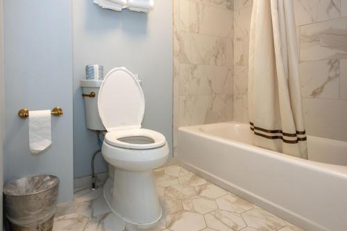 a bathroom with a toilet and a tub and a sink at Eliza Thompson House, Historic Inns of Savannah Collection in Savannah