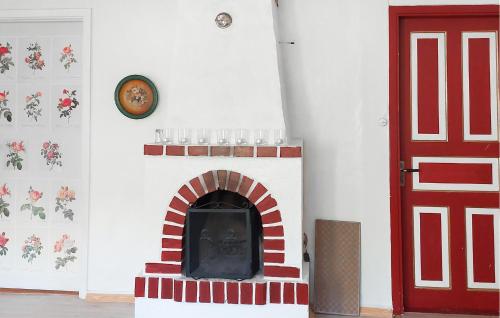 a room with a fireplace with a red door at Awesome Home In Alsterbro With Wifi in Alsterbro