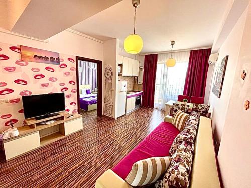 a living room with a couch and a flat screen tv at Summerland Seaview Apartments in Mamaia