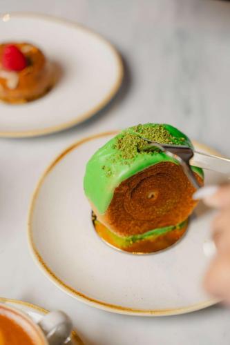 a donut on a white plate with a spoon at Radisson Blu Hotel Riyadh Convention and Exhibition Center in Riyadh
