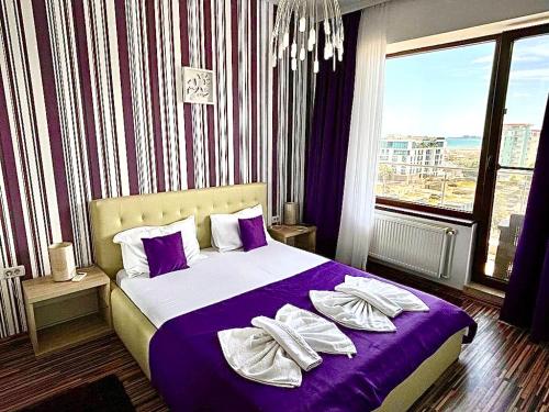a bedroom with a large bed with purple sheets and pillows at Summerland Seaview Apartments in Mamaia