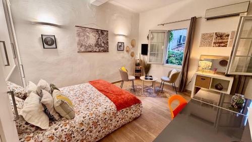 une chambre avec un lit, un bureau et une fenêtre dans l'établissement L'AIXCAPADE studio cosy centre historique, à Aix-en-Provence