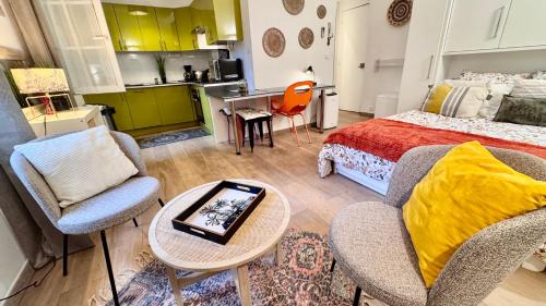une chambre avec un lit, une table et des chaises dans l'établissement L'AIXCAPADE studio cosy centre historique, à Aix-en-Provence