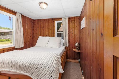 a small room with a bed and a window at Chippewa Bluffs Resort Combined 4BR 4BA Cabins in Barryton
