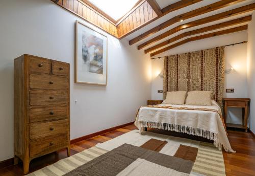 a bedroom with a large bed and a dresser at Casa Balteira da Terra, Cedeira in Cedeira